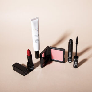 Gamme de maquillage 1944 Paris avec rouge à lèvres, blush, mascara et BB crème sur fond beige.