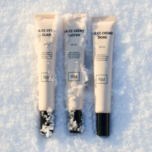 CC Crème SPF 30 1944 Paris teintes clair moyen et doré disposées sur fond de neige, maquillage teint naturel lumineux