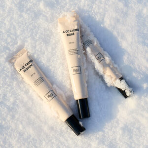 CC Crème SPF 30 1944 Paris teintes clair moyen et doré disposées sur fond de neige, maquillage teint naturel lumineux