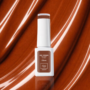 Flacon de vernis gel vegan couleur brun caramel chaud teinte Elora NGV277 sur fond texturé brillant assorti.