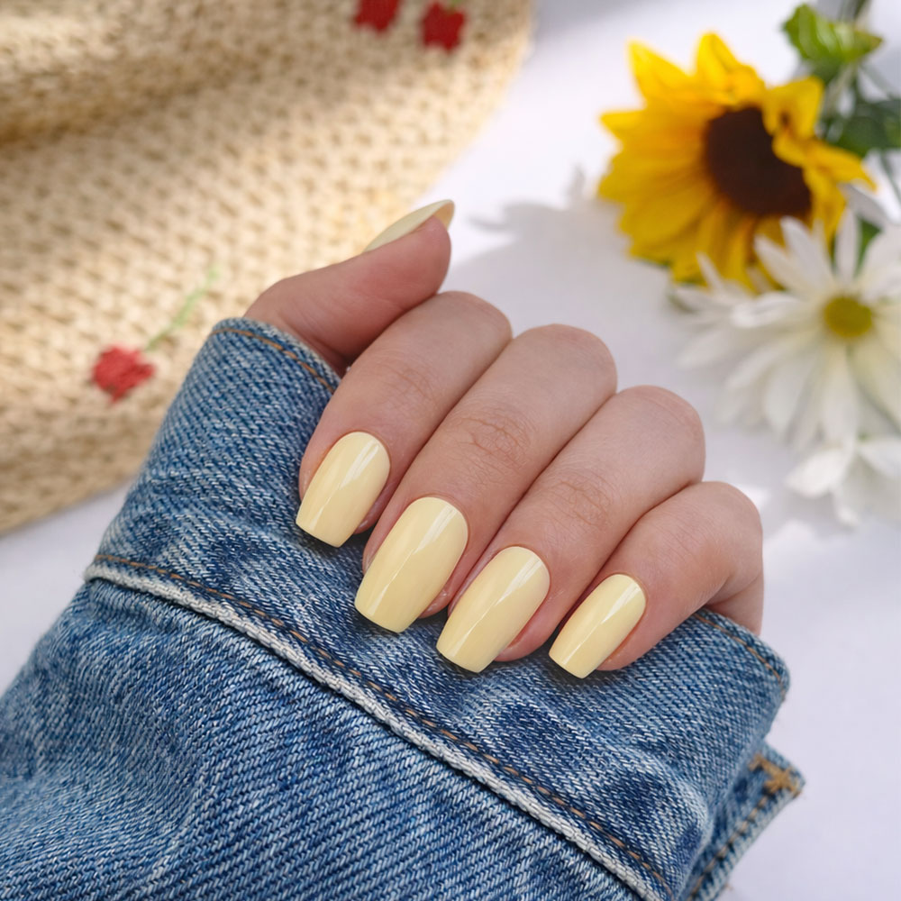 Pastel yellow nail varnish 1944 Paris on natural manicure with denim jacket and spring flowers