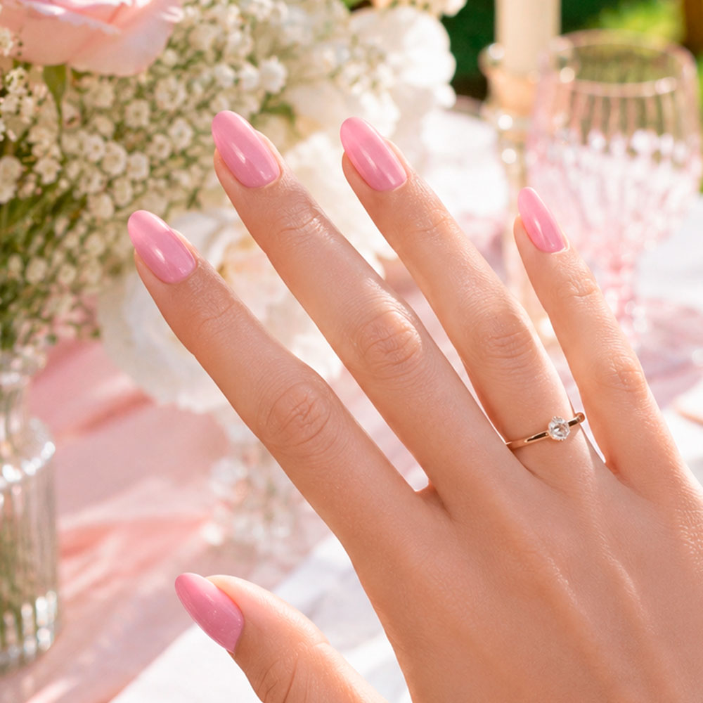 Ongles rose lumineux et glossy sublimant les mains avec une finition douce et romantique pour le jour du mariage.