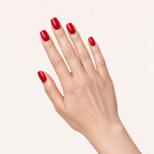 Hands with a manicure featuring Karine vegan nail varnish, in a deep red shade, on a pinkish-beige base – 1944 Paris