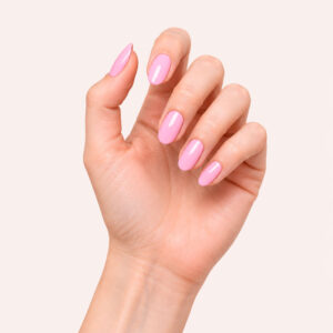 A hand with fair skin wearing Ellen’s candy-pink vegan semi-permanent gel, against a pale pink background