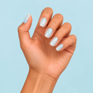 Giulia’s shimmering bluish-white manicure on a light blue background – 1944 Paris Vegan Gel