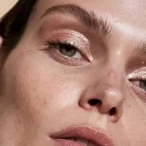Retrato con el lápiz brillante Glow 1944 Paris, sombra de ojos en tono melocotón rosado y un suave brillo en el rostro